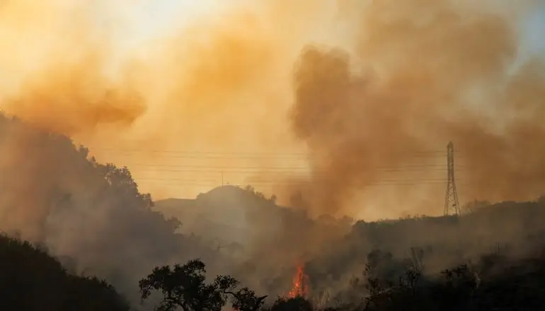 The Bond Fire wildfire continues to burn next to electrical power lines near Modjeska Canyon, California